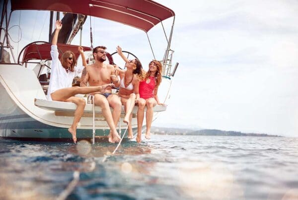 Watercraft Insurance - Group of Young Friends Sitting Together While Sailing on a Yacht and Enjoying a Summer Vacation